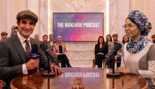 Two podcast hosts holding microphones during a live recording